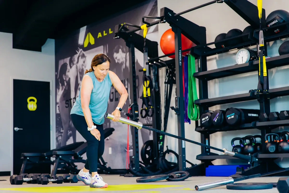 A member lifts the end of a landmine barbell during a strength session at Alloy Personal Training Royal Oak in Royal Oak, MI.